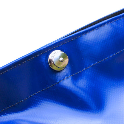 Close-up of a blue fabric surface with a metal button on a white background