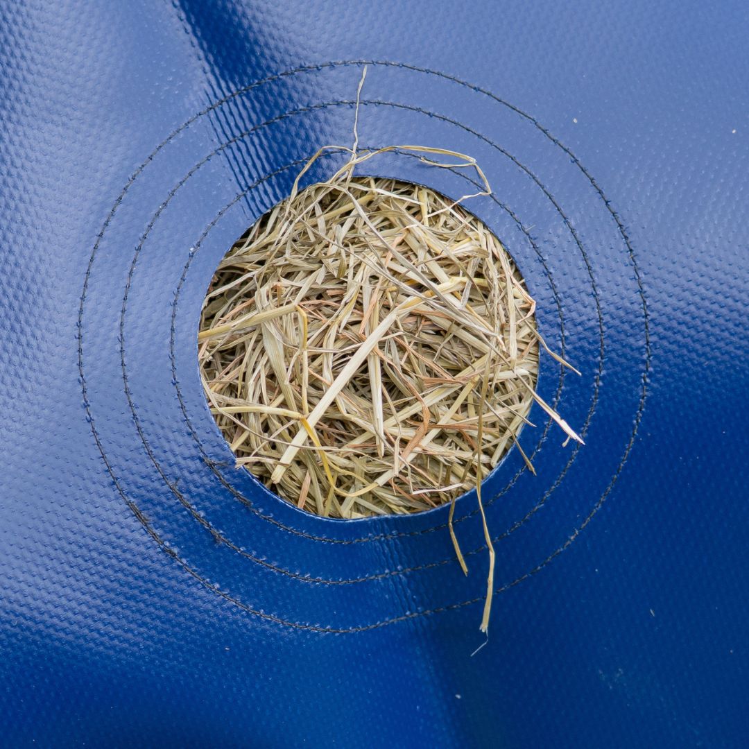Hay inside a reinforced hole in slow feeder