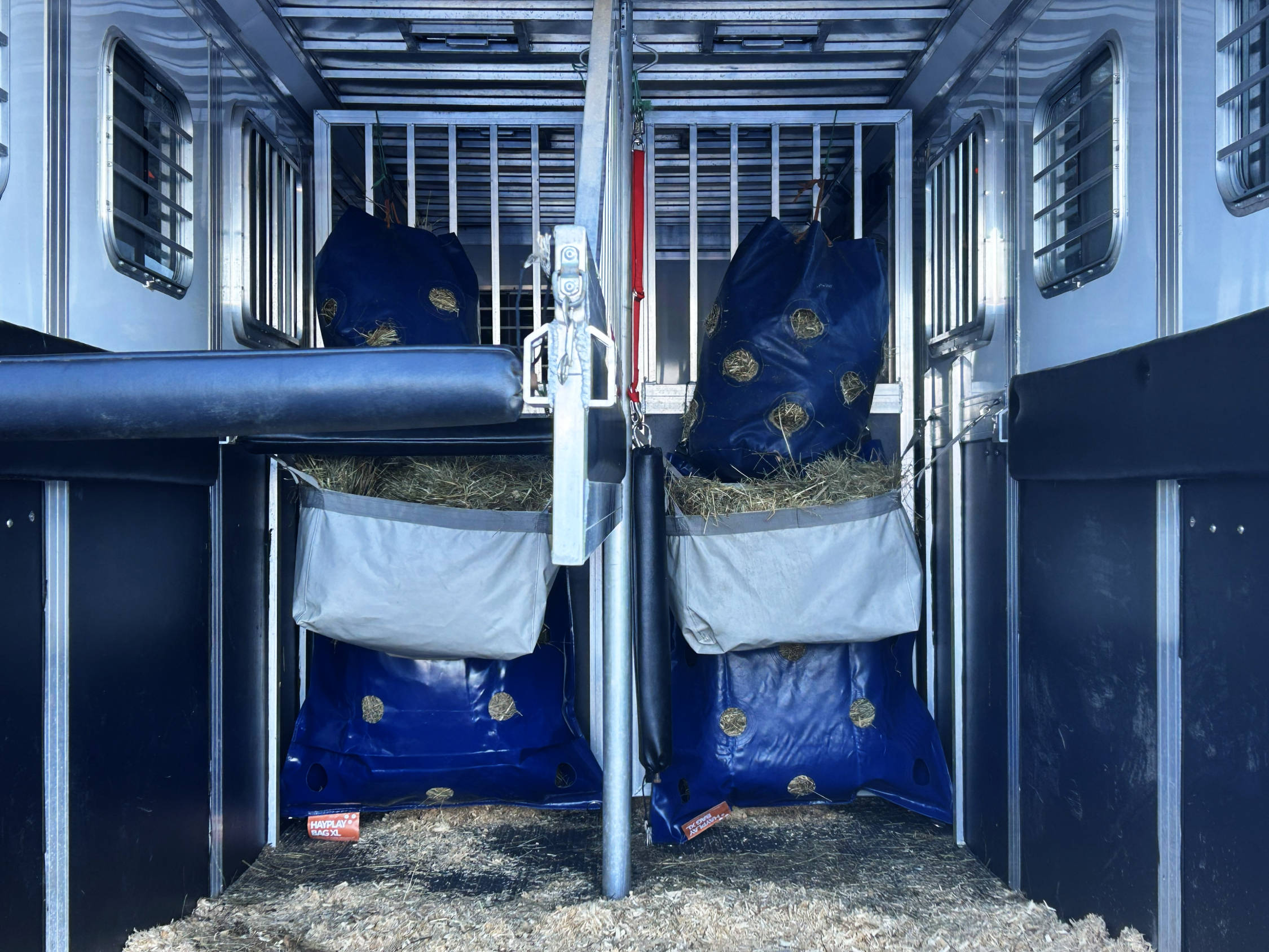 Horse trailer interior with hay bales in hay bags for extra storage